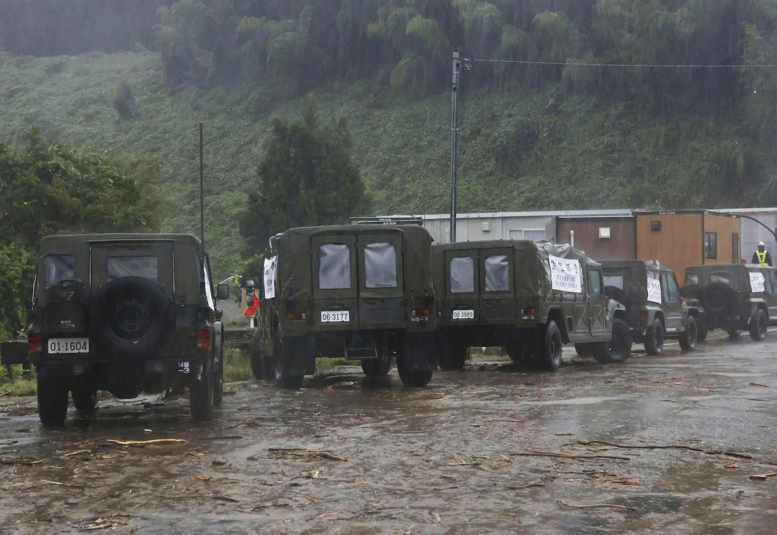 Japan's Self-Defense Forces vehicles deployed to support people in areas affected by severe weather are parked on a mud-covered road in Wajima, Japan, Sunday, Sept. 22, 2024, following heavy rain in central Japan's Noto peninsula area. (Katsunori Nishioka/Kyodo News via AP)