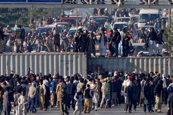 Supporters of imprisoned former premier Imran Khan's Pakistan Tehreek-e-Insaf party, remove shipping container to clear way for their rally demanding Khan's release, in Islamabad, Pakistan, Tuesday, Nov. 26, 2024. (AP Photo/Anjum Naveed)