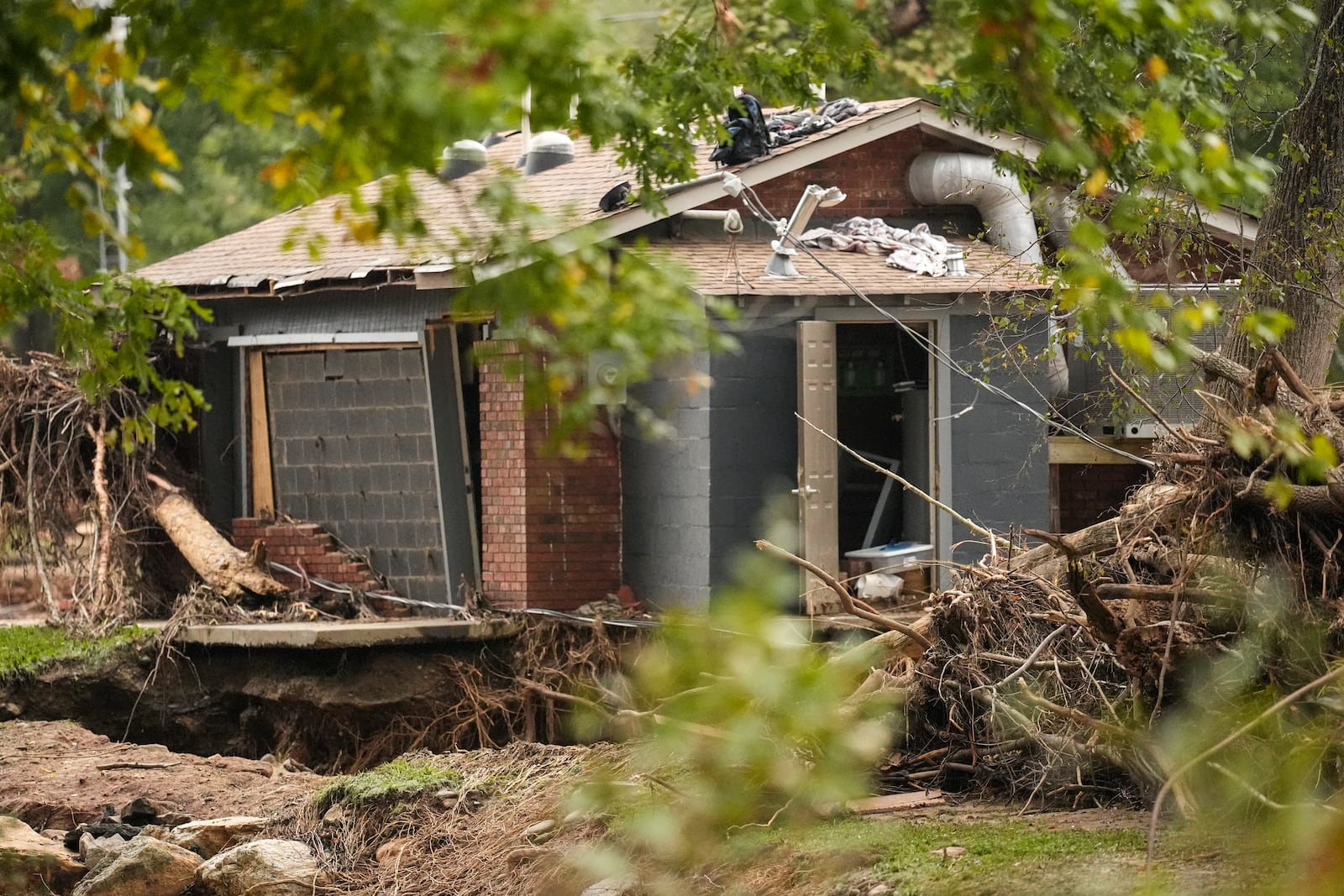 A building is damaged as water rushed over the roof in the aftermath of Hurricane Helene, Tuesday, Oct. 1, 2024, in Swannanoa, N.C. (AP Photo/Mike Stewart)