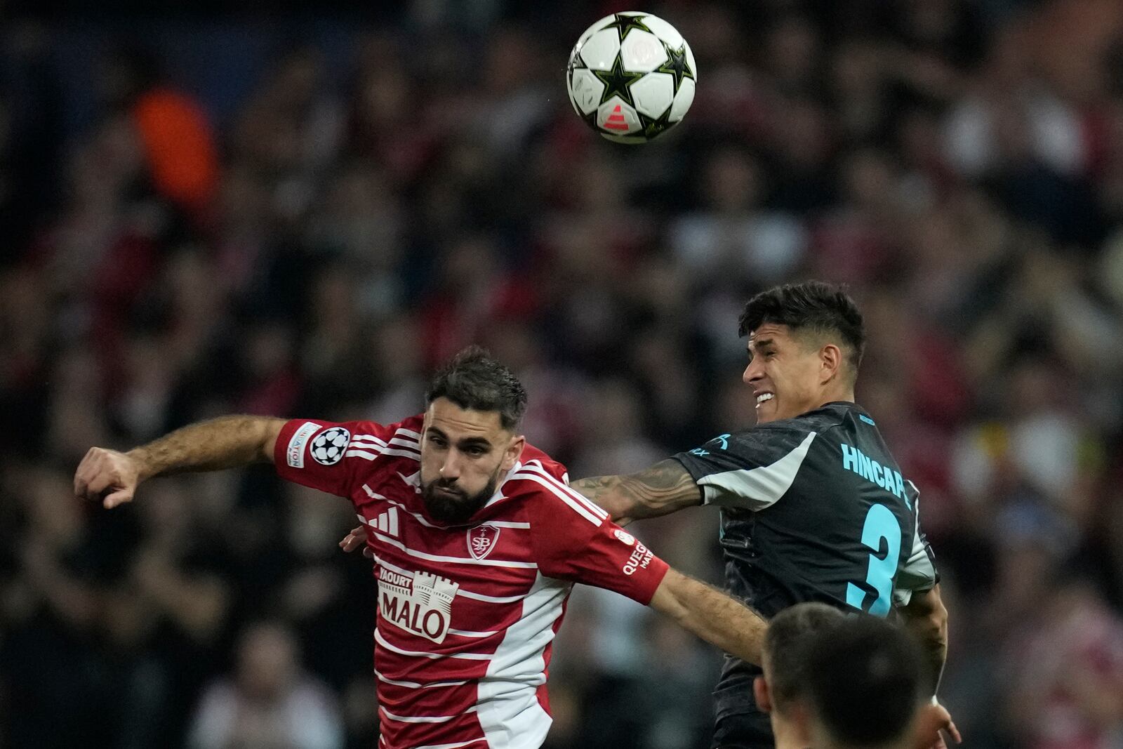 Brest's Romain Del Castillo, left, and Leverkusen's Piero Hincapie jump for the ball during the Champions League opening phase soccer match between Brest and Bayer Leverkusen in Guingamp, western France, Wednesday, Oct. 23, 2024. (AP Photo/Christophe Ena)