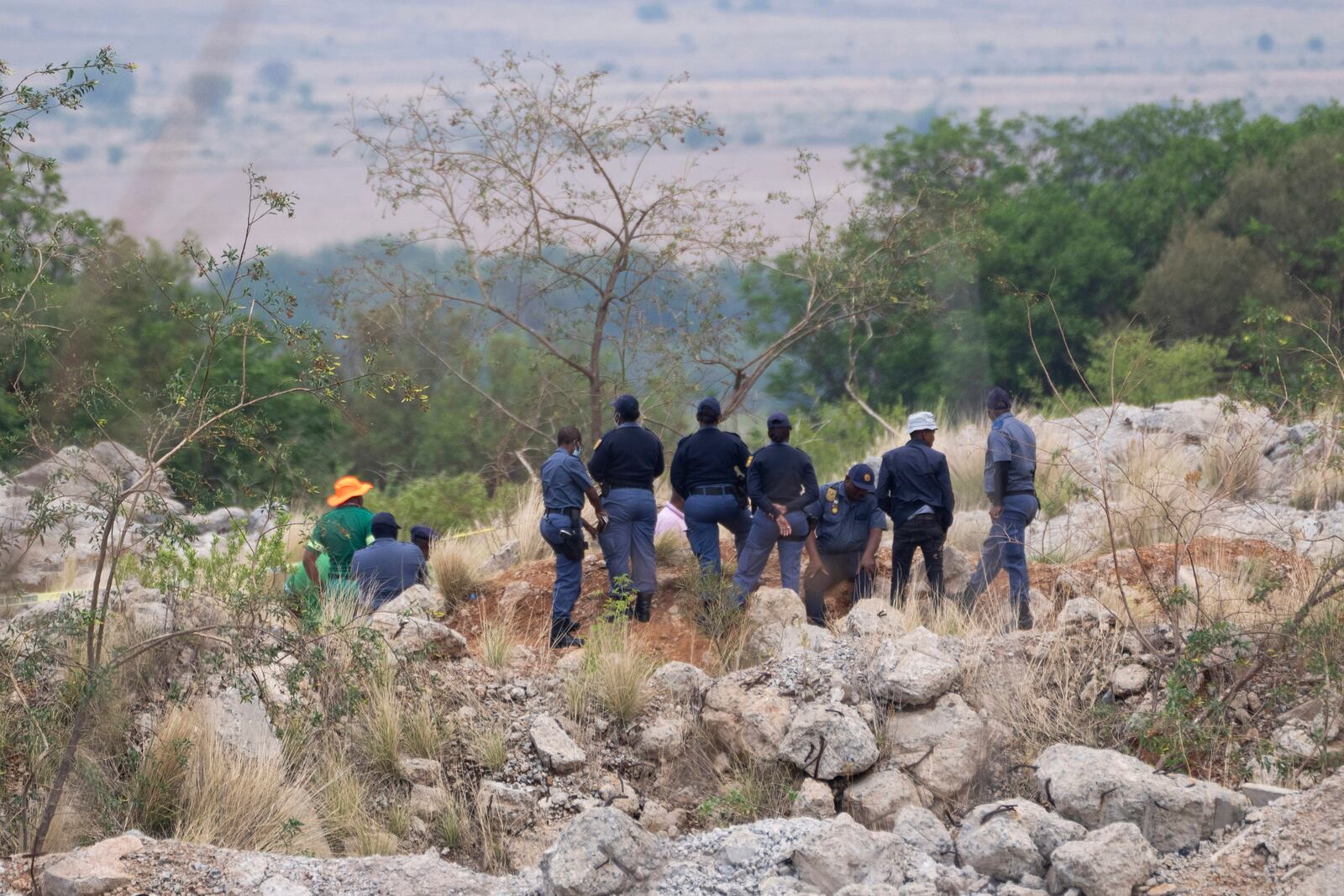 Rescue workers, left, remove a body from a reformed mineshaft where illegal miners are trapped inside a disused mine in Stilfontein, South Africa, Thursday, Nov.14, 2024. (AP Photo/Jerome Delay)