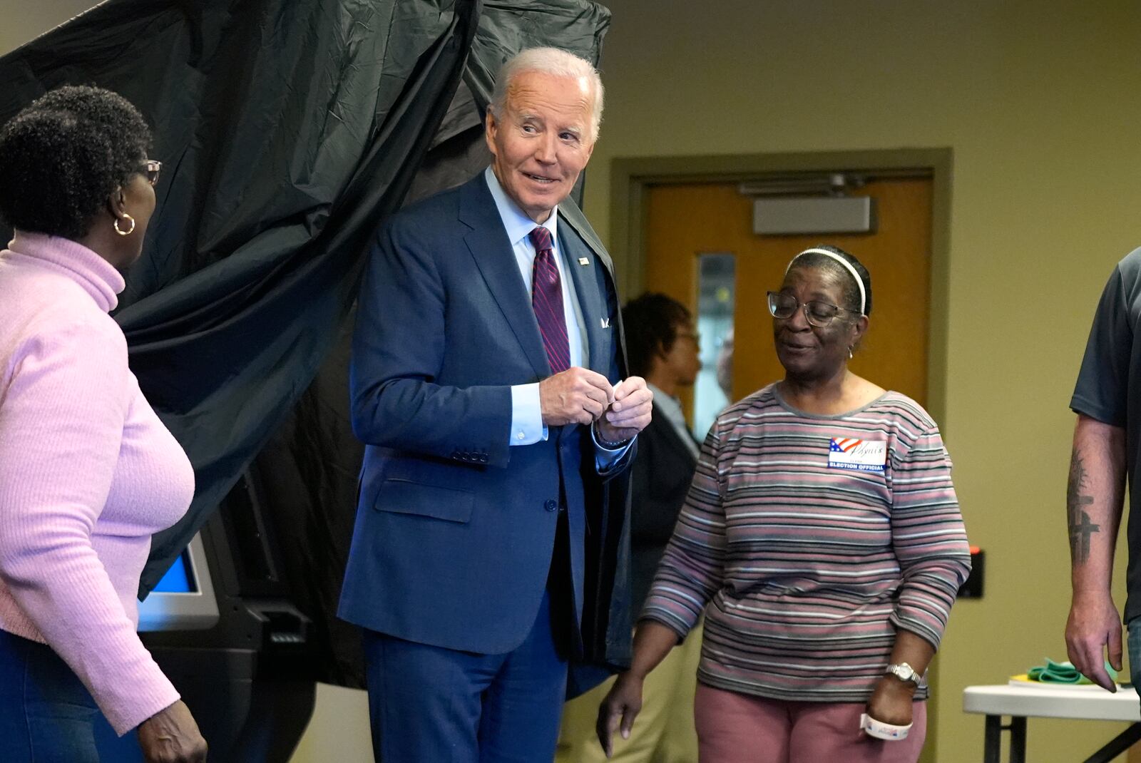 President Joe Biden, center, holds an "I Voted Early" sticker upon exiting the voting booth after casting his early-voting ballot for the 2024 general elections, Monday, Oct. 28, 2024, in New Castle, Del. (AP Photo/Manuel Balce Ceneta)