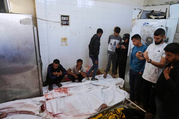 Palestinian mourn their relatives who were killed in an Israeli army airstrike on the Gaza Strip, at the morgue of Al-Aqsa Hospital in Deir al-Balah, Gaza, Thursday, May 22, 2025. (AP Photo/Abdel Kareem Hana)