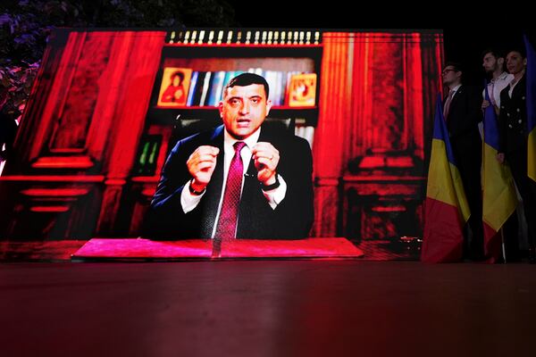 Presidential candidate George Simion is shown on a screen at the meeting of his supporters after polls closed for the first round of the country's presidential election redo in Bucharest, Romania, Sunday, May 4, 2025. (AP Photo/Andreea Alexandru)