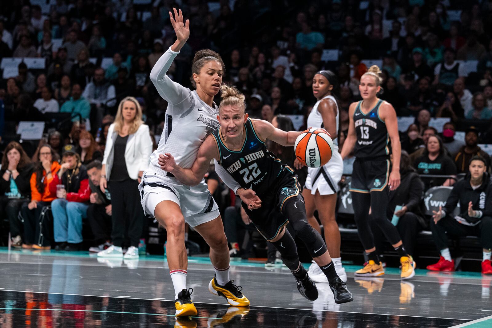 New York Liberty guard Courtney Vandersloot (22) is defended by Las Vegas Aces forward Alysha Clark, left, during the first half of a WNBA basketball second-round playoff game, Sunday, Sept. 29, 2024, in New York. (AP Photo/Corey Sipkin)