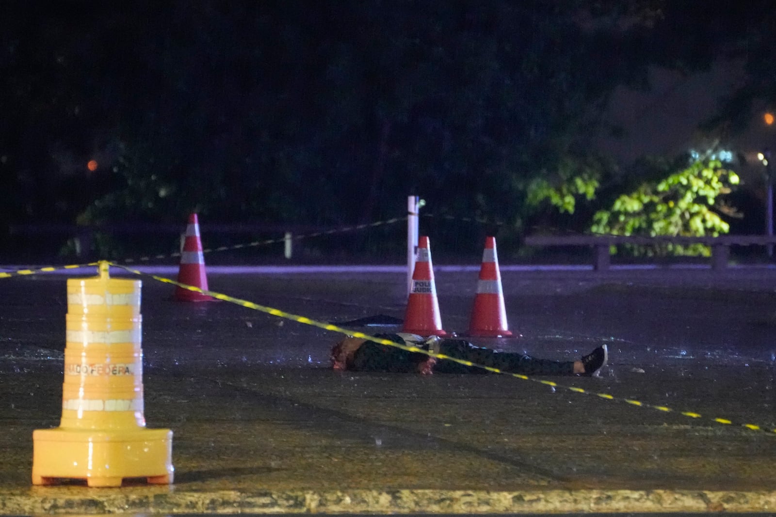 A body lies on a road outside the Supreme Court in Brasília, Brazil, following an explosion, Wednesday, Nov. 13, 2024. (AP Photo/Eraldo Peres)