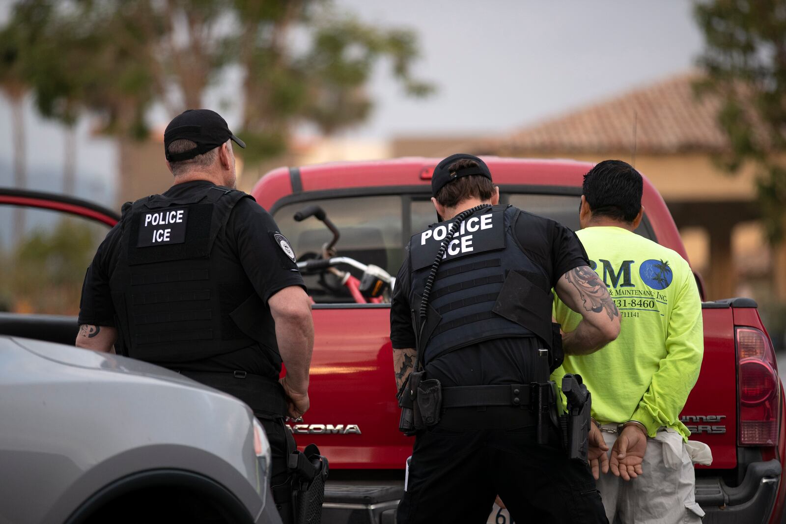 In this July 8, 2019, photo, a U.S. Immigration and Customs Enforcement (ICE) officers detain a man during an operation in Escondido, Calif. (AP Photo/Gregory Bull)