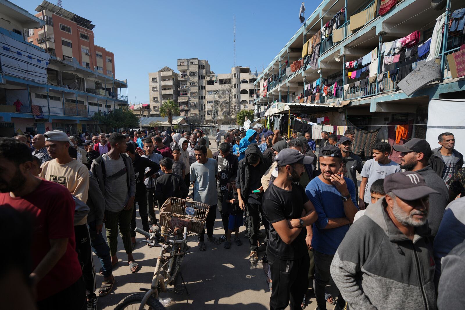 Palestinians gather to receive aid distributed by UNRWA, the U.N. agency helping Palestinian refugees, in Nusairat refugee camp, Gaza, Tuesday, Nov. 5, 2024. (AP Photo/Abdel Kareem Hana)