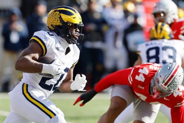 Michigan running back Kalel Mullings, left, runs the ball against Ohio State during the first half of an NCAA college football game Saturday, Nov. 30, 2024, in Columbus, Ohio. (AP Photo/Jay LaPrete)