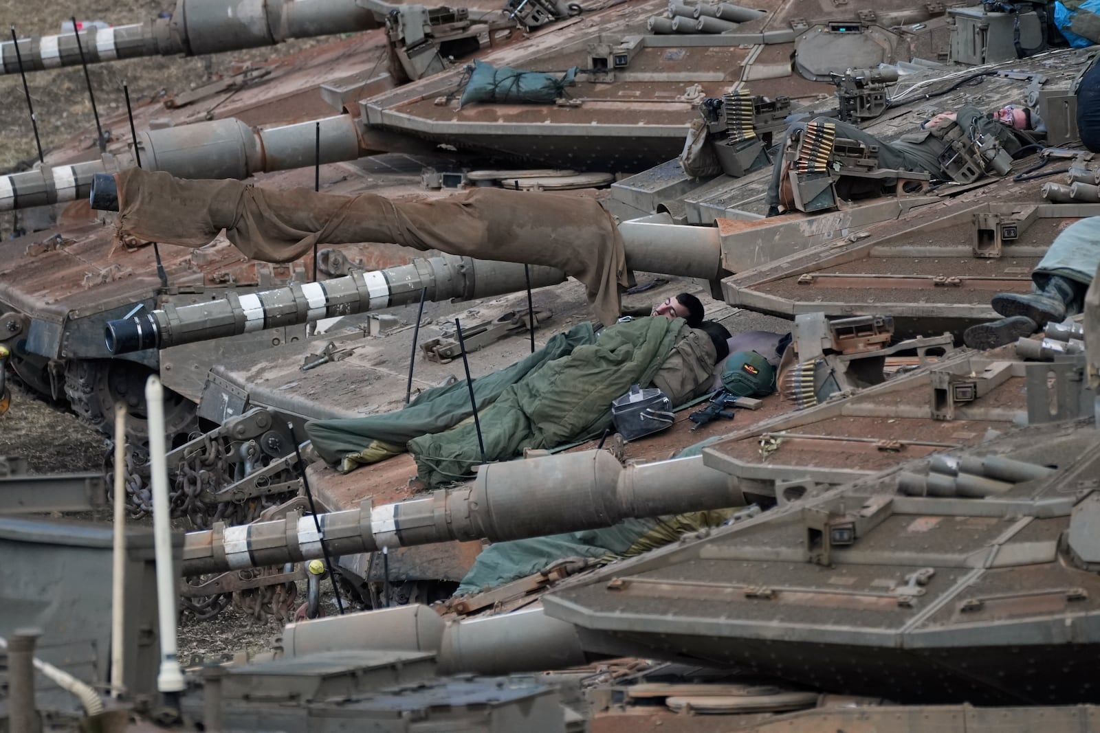 Israeli soldiers sleep on tanks in a staging area in northern Israel near the Israel-Lebanon border, Tuesday, Oct. 1, 2024. (AP Photo/Baz Ratner)