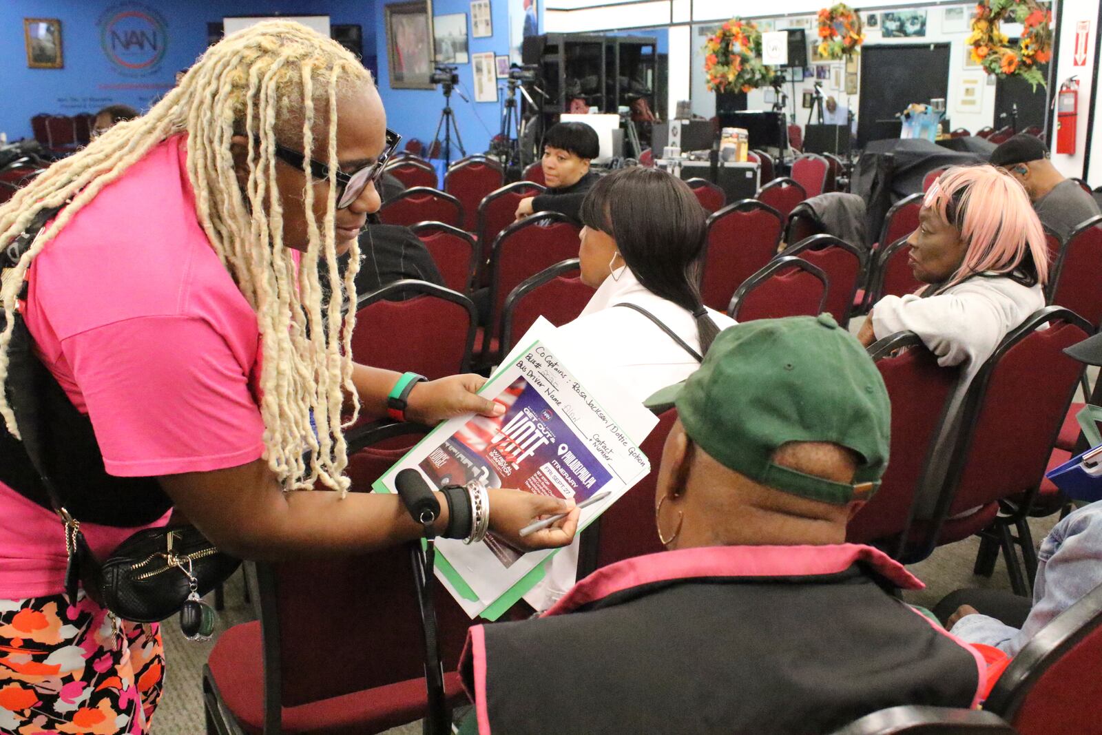 An organizer with the National Action Network signs people in ahead of a Get Out the Vote bus tour toward Philadelphia in the Harlem neighborhood of New York on Friday, Sep. 27, 2024. (AP Photo/Noreen Nasir)