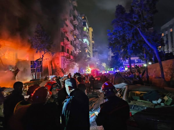 Civil defense workers extinguish a fire at the site of an Israeli airstrike in Beirut, Sunday, Nov. 17, 2024. (AP Photo/Hassan Ammar)