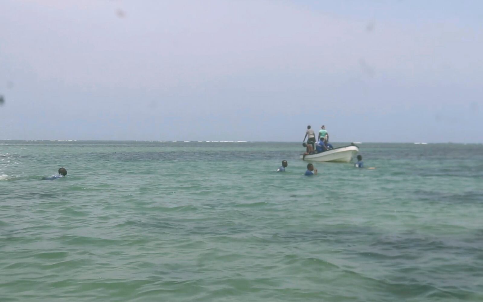 In this image made from video, Djiboutian coast guard workers search for bodies of migrants who were washed away on the shore of the Red Sea, off the coast in Djibouti Wednesday, Oct. 2, 2024. ( Djiboutian Coast Guard via AP)