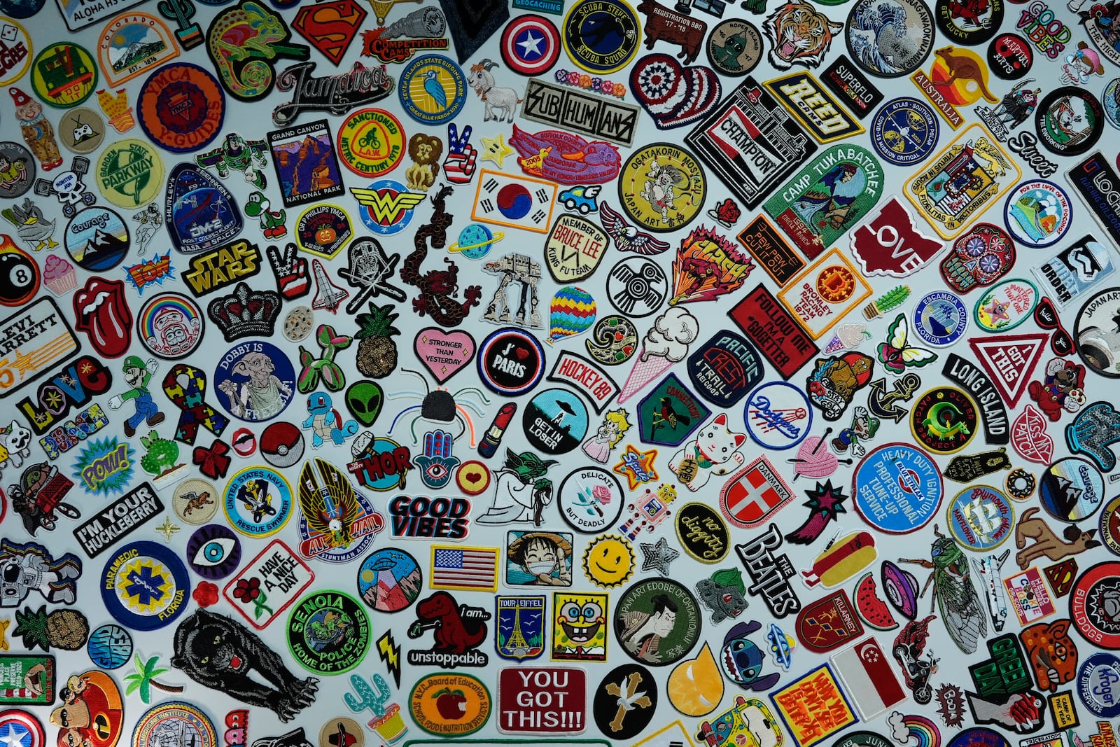 A wall displays some of the thousands of patches sent to Oliver Burkhardt when he was undergoing cancer treatment at age 9, inside the offices of the Oliver Patch Project, Wednesday, Sept. 4, 2024, in Miami. (AP Photo/Rebecca Blackwell)