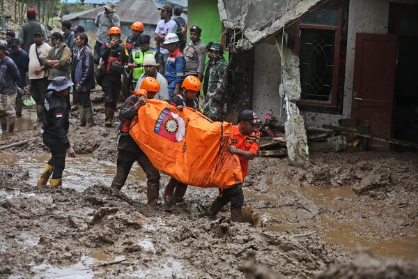 Rescuers carry the body of a victim of the landslide in Karo, North Sumatra, Indonesia, Monday, Nov. 25, 2024. (AP Photo/Binsar Bakkara)