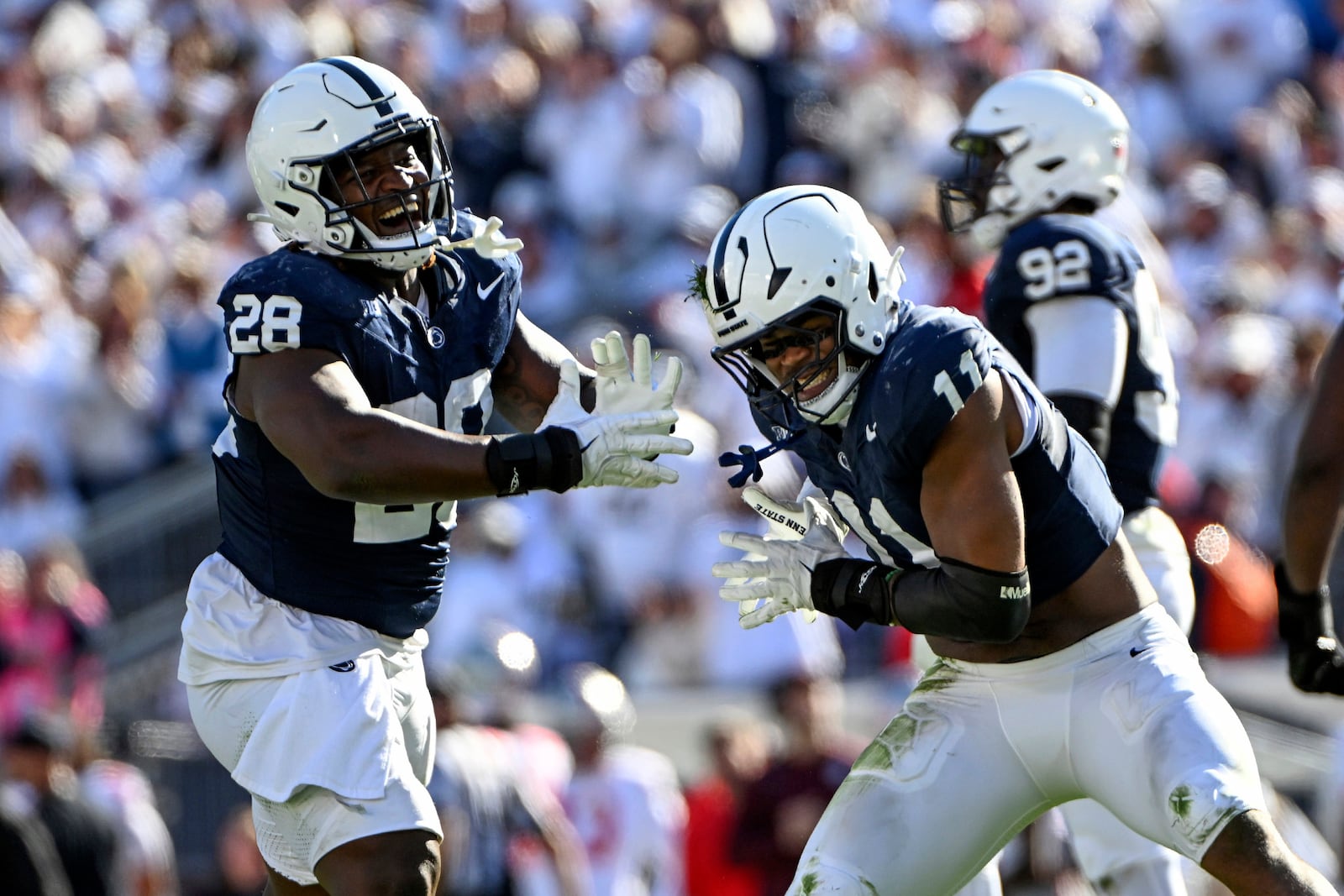 Penn State defensive end Abdul Carter (11) and Zane Durant (28) celebrate a sack of Ohio State quarterback Will Howard (18) during the second half of an NCAA college football game against Ohio State, Saturday, Nov. 2, 2024, in State College, Pa. (AP Photo/Barry Reeger)