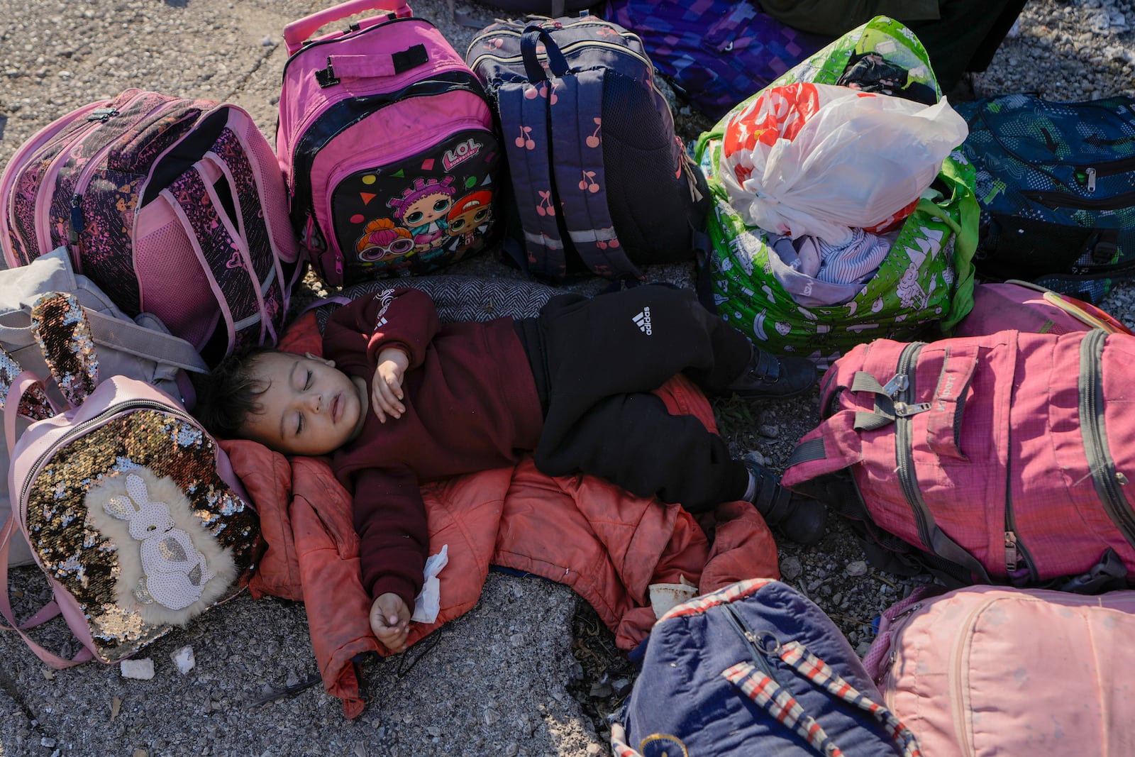 A child sleeps on the ground in Beirut's Martyrs' square after fleeing the Israeli airstrikes in the southern suburbs of Dahiyeh, Saturday, Sept. 28, 2024. (AP Photo/Bilal Hussein)