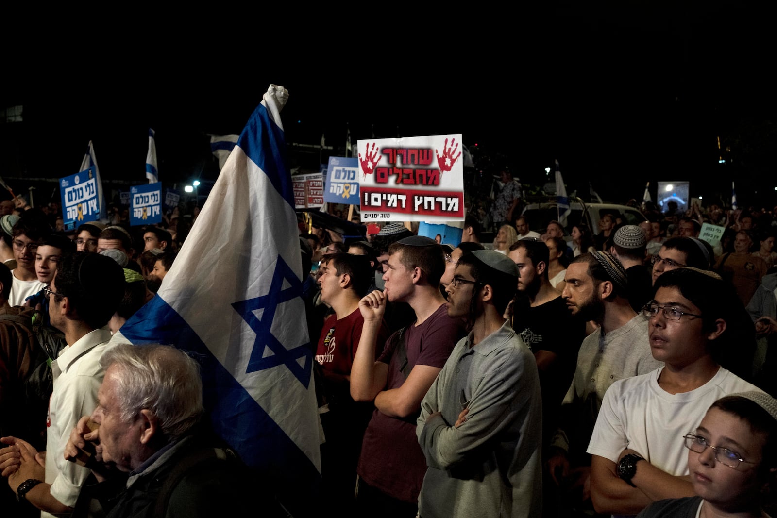 Right-wing Israelis with relatives held hostage by Hamas in the Gaza Strip, and their supporters, rally against a hostage deal, in Jerusalem, Thursday, Sept. 19, 2024. The placard in Hebrew reads: " To bathe in his blood." (AP Photo/Maya Alleruzzo)