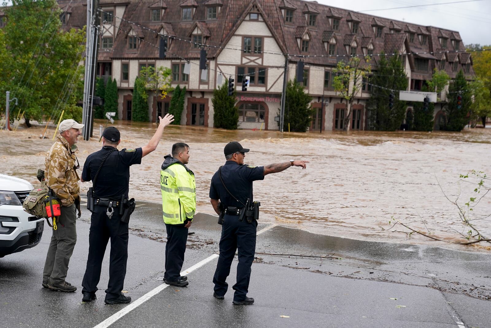 Emergency personnel watch as floodwaters rise, Friday, Sept. 27, 2024, in Asheville, N.C. (AP Photo/Erik Verduzco)