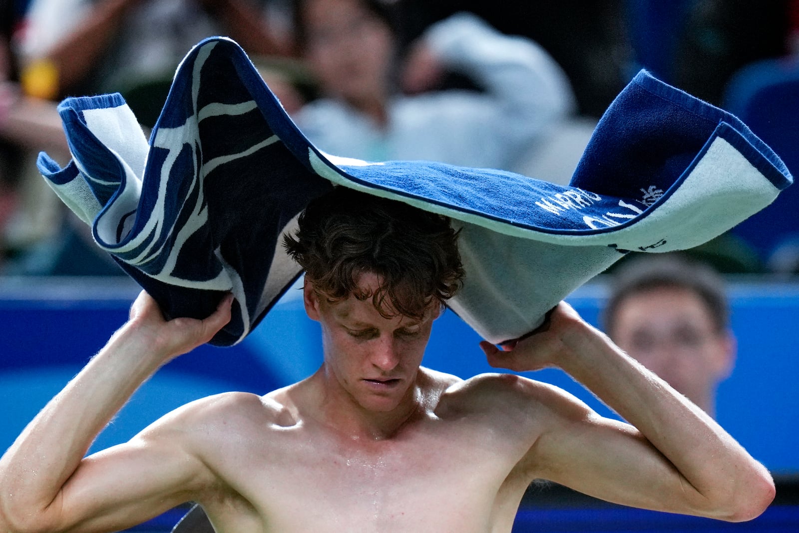 Jannik Sinner of Italy wipes his sweat during a set break in the men's singles match against Tomas Martin Etcheverry of Argentina in the Shanghai Masters tennis tournament at Qizhong Forest Sports City Tennis Center in Shanghai, China, Sunday, Oct. 6, 2024. (AP Photo/Andy Wong)