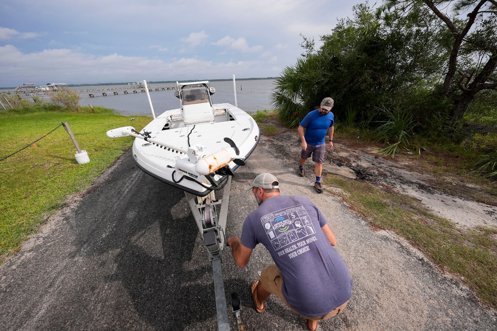 Bo Manausa , right, and his friend Josh Simmons pull a boat out of the water ahead of Hurricane Helene, expected to make landfall Thursday evening, in Alligator Point, Fla., Wednesday, Sept. 25, 2024. (AP Photo/Gerald Herbert)