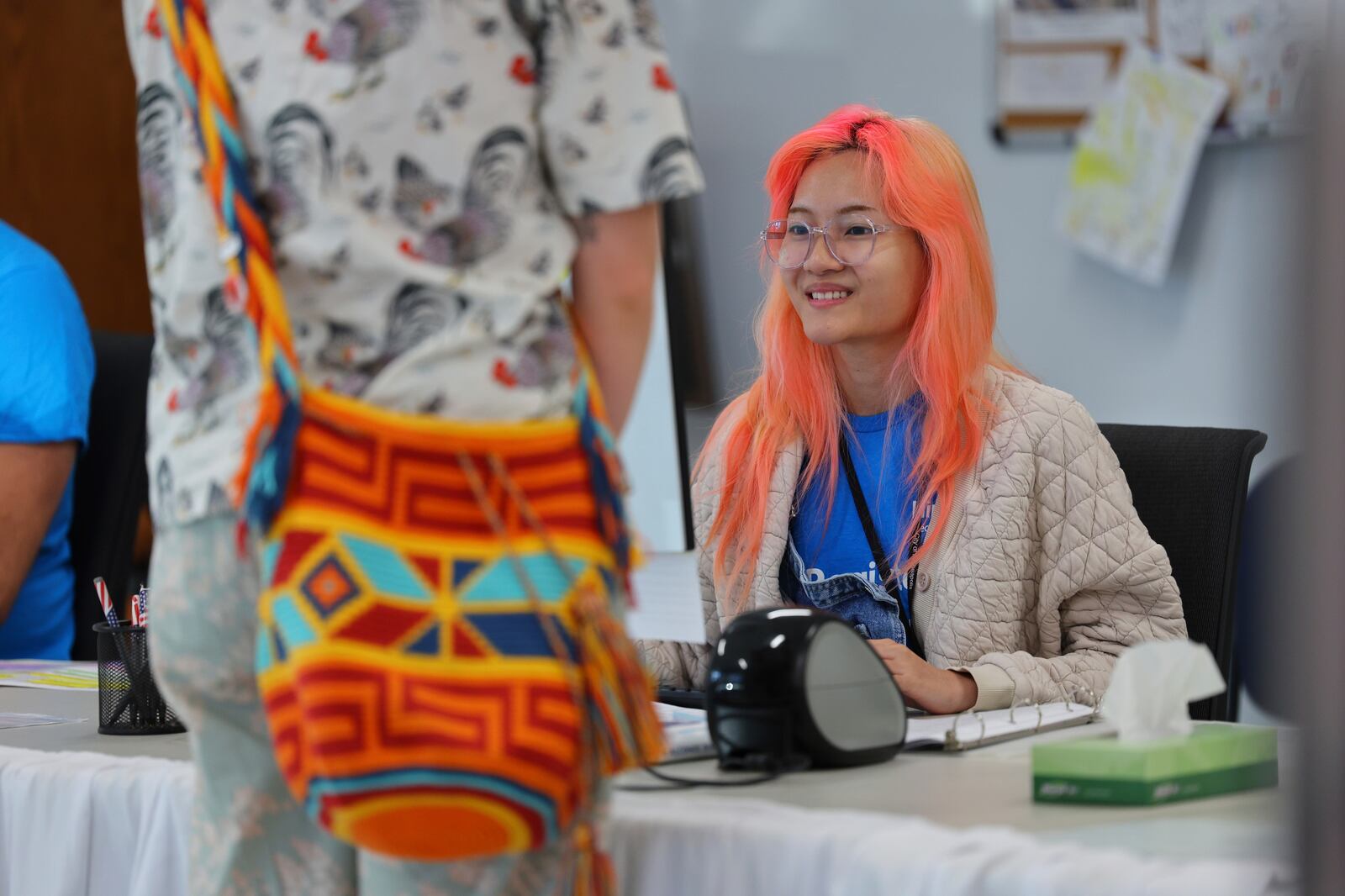 Elections staff assist early voters line up at the City of Minneapolis early voting center, Friday, September 20, 2024, in Minneapolis, Minn. (AP Photo/Adam Bettcher)