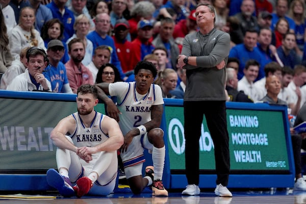 Kansas head coach Bill Self watches with center Hunter Dickinson, left, and guard AJ Storr (2) during the second half of an NCAA college basketball game against UNC Wilmington, Tuesday, Nov. 19, 2024, in Lawrence, Kan. (AP Photo/Charlie Riedel)