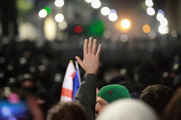 Demonstrators stand in front of police during a rally outside the parliament's building to protest the government's decision to suspend negotiations on joining the European Union for four years in Tbilisi, Georgia, on Saturday, Nov. 30, 2024. (AP Photo/Zurab Tsertsvadze)