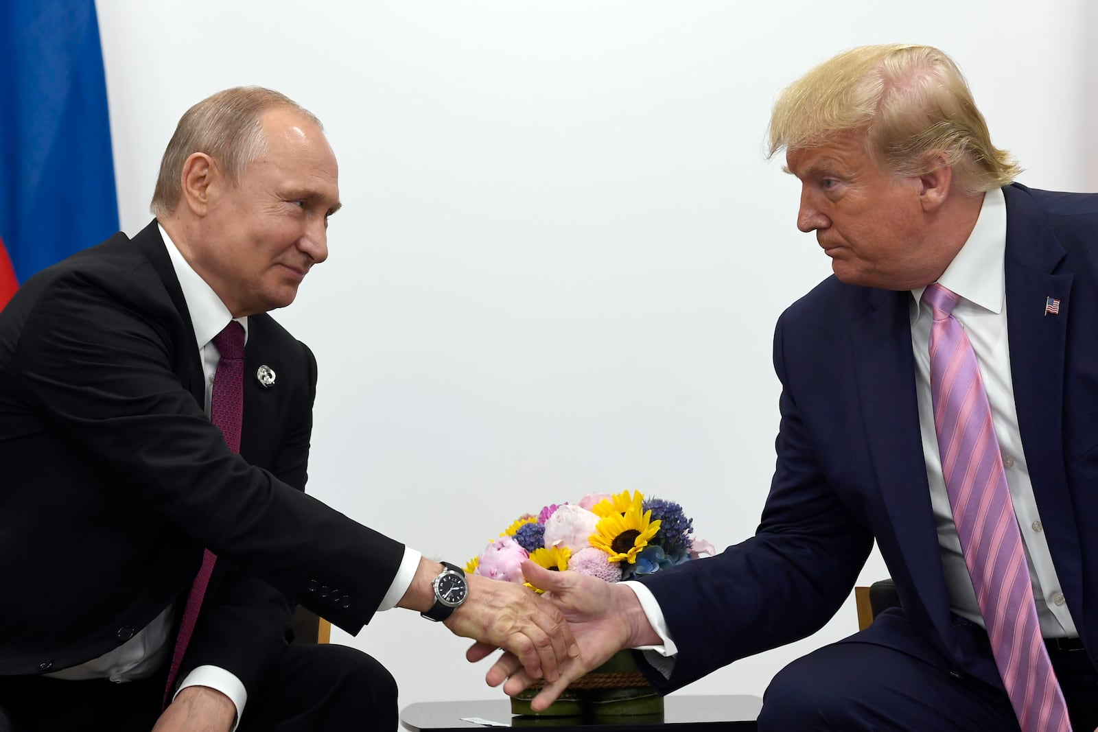 FILE - In this June 28, 2019, file photo, President Donald Trump, right, shakes hands with Russian President Vladimir Putin, left, during a bilateral meeting on the sidelines of the G-20 summit in Osaka, Japan. (AP Photo/Susan Walsh, File)