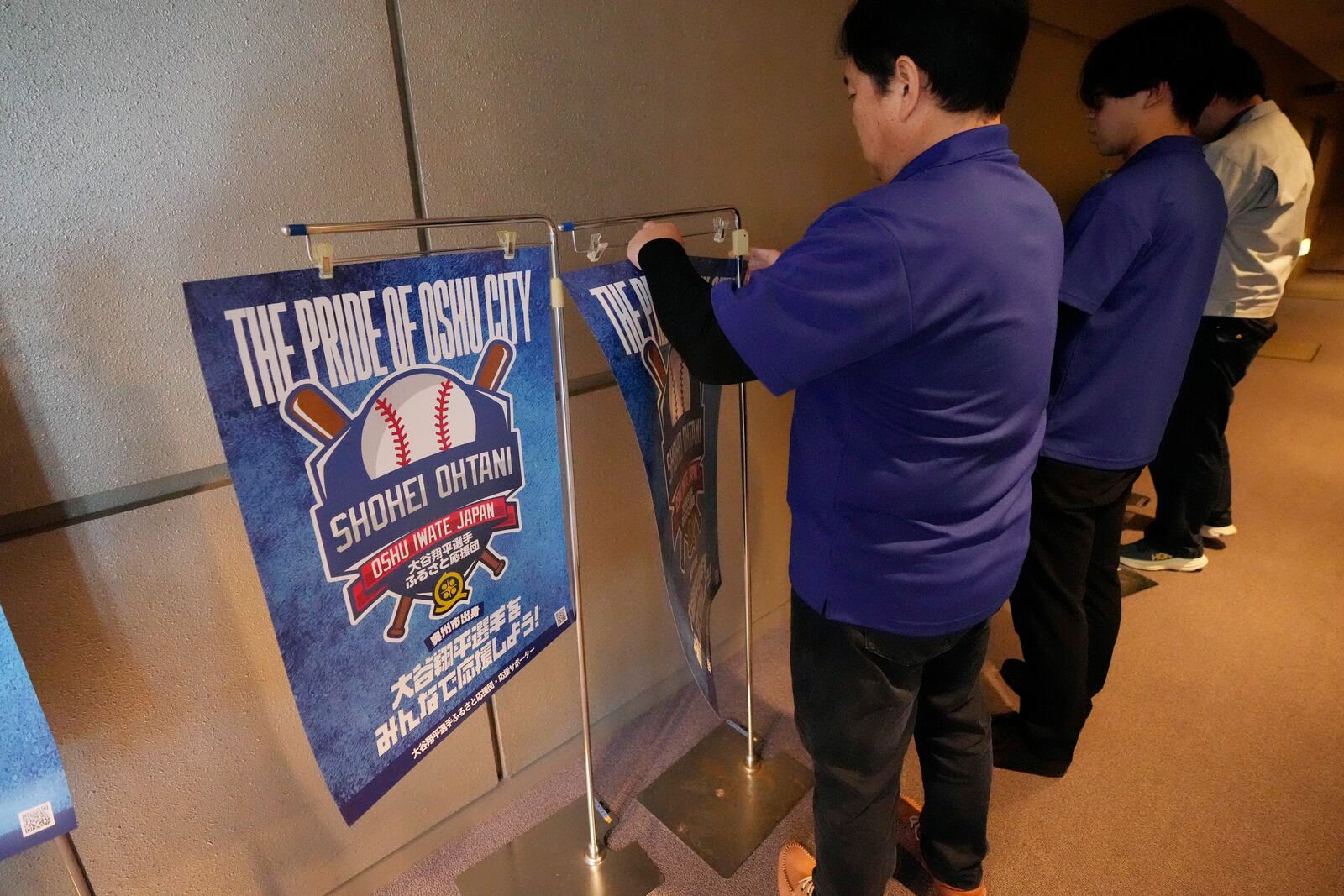 Staff members of a public viewing event for Game 3 of the baseball World Series between the Los Angeles Dodgers and the New York Yankees prepare the venue before the game live stream in Oshu, northeastern Japan, the hometown of Shohei Ohtani of the Dodgers, Tuesday, Oct. 29, 2024. (AP Photo/Eugene Hoshiko)