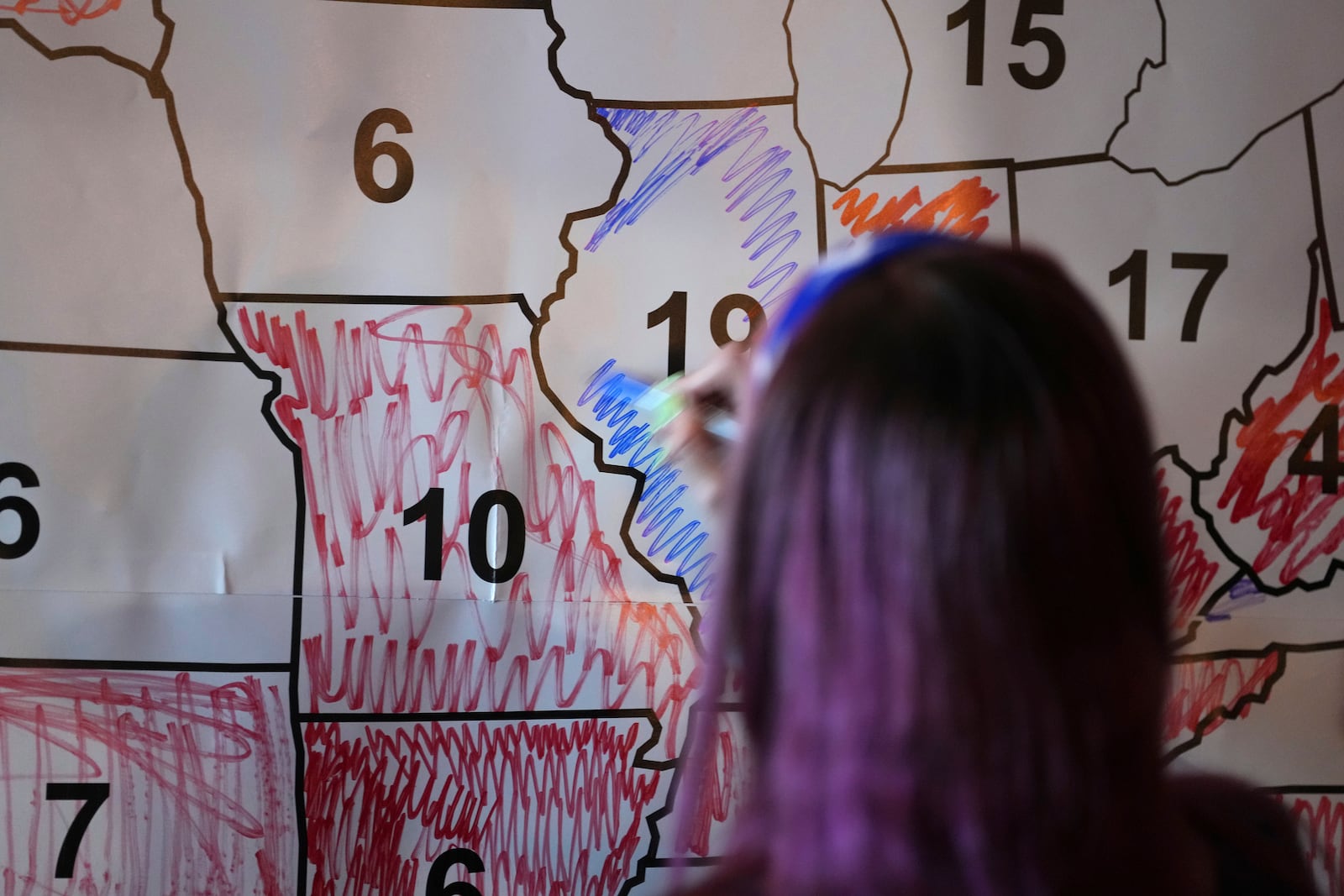 A voter colors the state of Illinois blue during an election night watch party, Tuesday, Nov. 5, 2024, in Cincinnati. (AP Photo/Kareem Elgazzar)