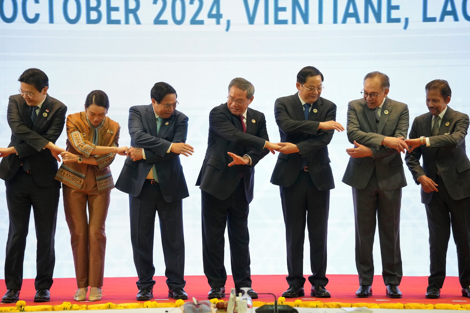 From left, Singapore's Prime Minister Lawrence Wong, Thailand's Prime Minister Paetongtarn Shinawatra, Vietnam's Prime Minister Pham Minh Chinh, Chinese Premier Li Qiang, Laos' Prime Minister Sonexay Siphandone, Malaysia's Prime Minister Anwar Ibrahim and Brunei Sultan Hassanal Bolkiah hold hands for a photo session during the 27th Association of Southeast Asian Nations (ASEAN)-China Summit in Vientiane, Laos, Thursday, Oct. 10, 2024. (AP Photo/Dita Alangkara)