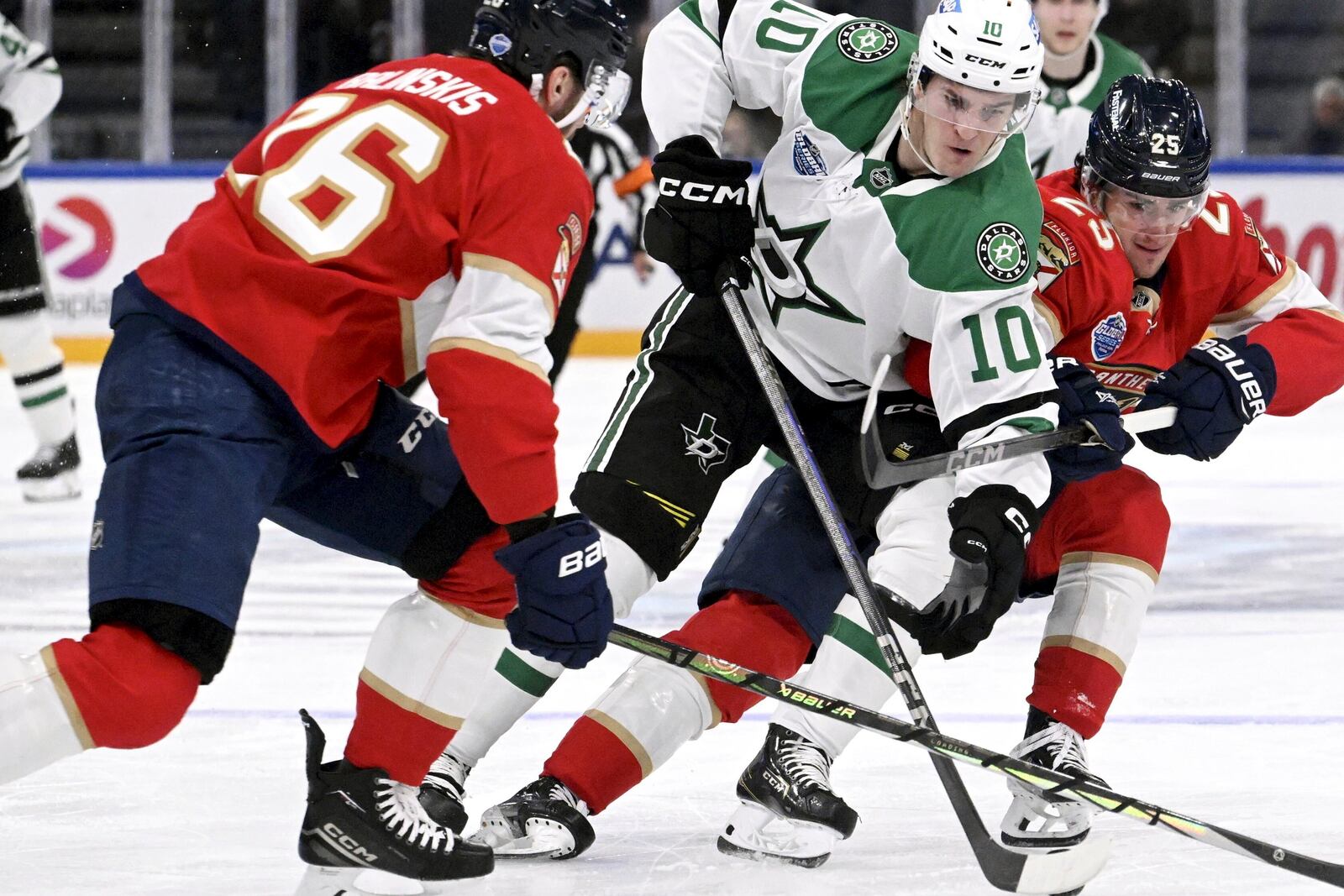 Dallas Stars' Oskar Bäck, center, splits the defense of Florida Panthers' Uvis Balinskis, left, and Mackie Samoskevichduring an NHL hockey game, Saturday, Nov. 2, 2024, in Tampere, Finland. (Heikki Saukkomaa/Lehtikuva via AP)