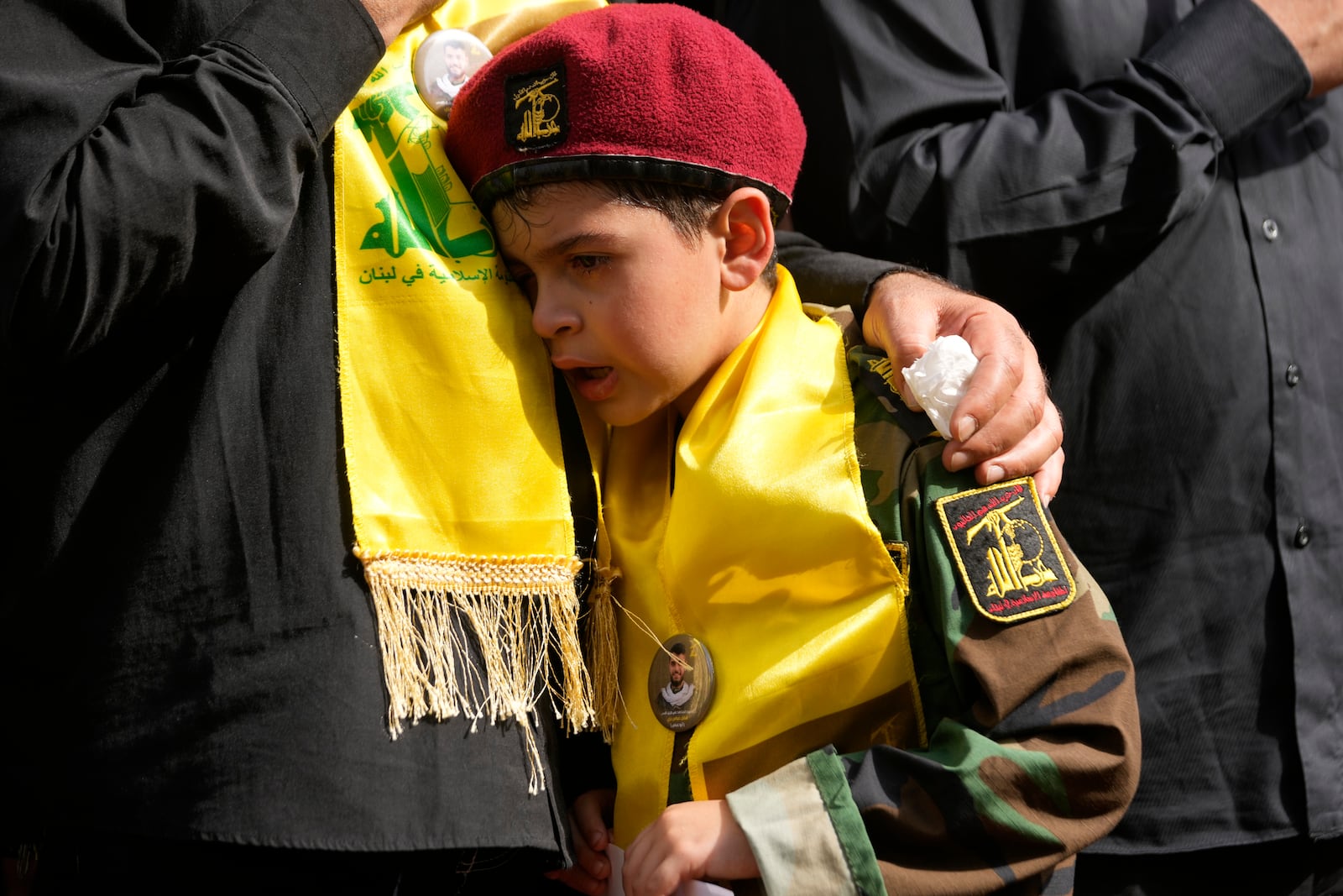 A boy cries during the funeral procession of two Hezbollah members in the southern suburbs of Beirut, Thursday, Sept. 19, 2024. (AP Photo/Hussein Malla)