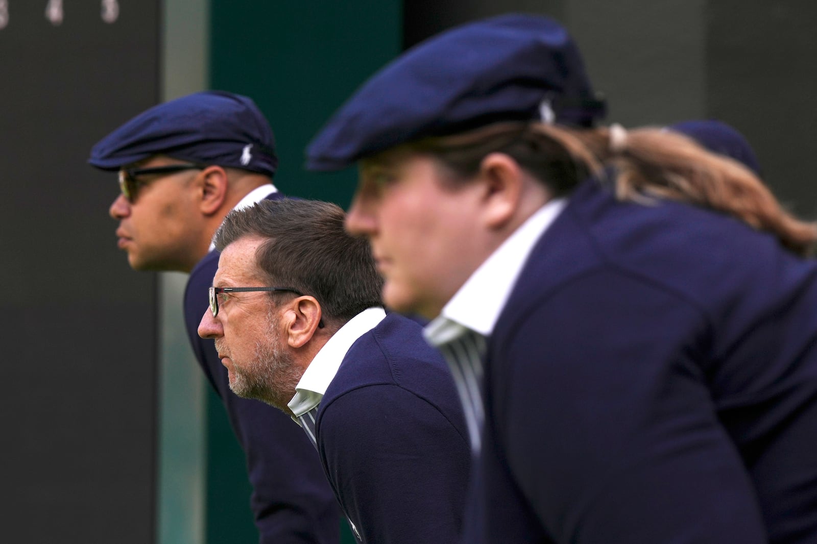 FILE - Line judges concentrate as Russia's Daniil Medvedev plays Britain's Arthur Fery in a first round men's singles match on day three of the Wimbledon tennis championships in London, Wednesday, July 5, 2023. That long-held Wimbledon tradition of line judges dressed in elegant uniforms is no more. The All England Club has announced that artificial intelligence will be used to make the 'out' and 'fault' calls at the championships from 2025. (AP Photo/Alberto Pezzali, File)