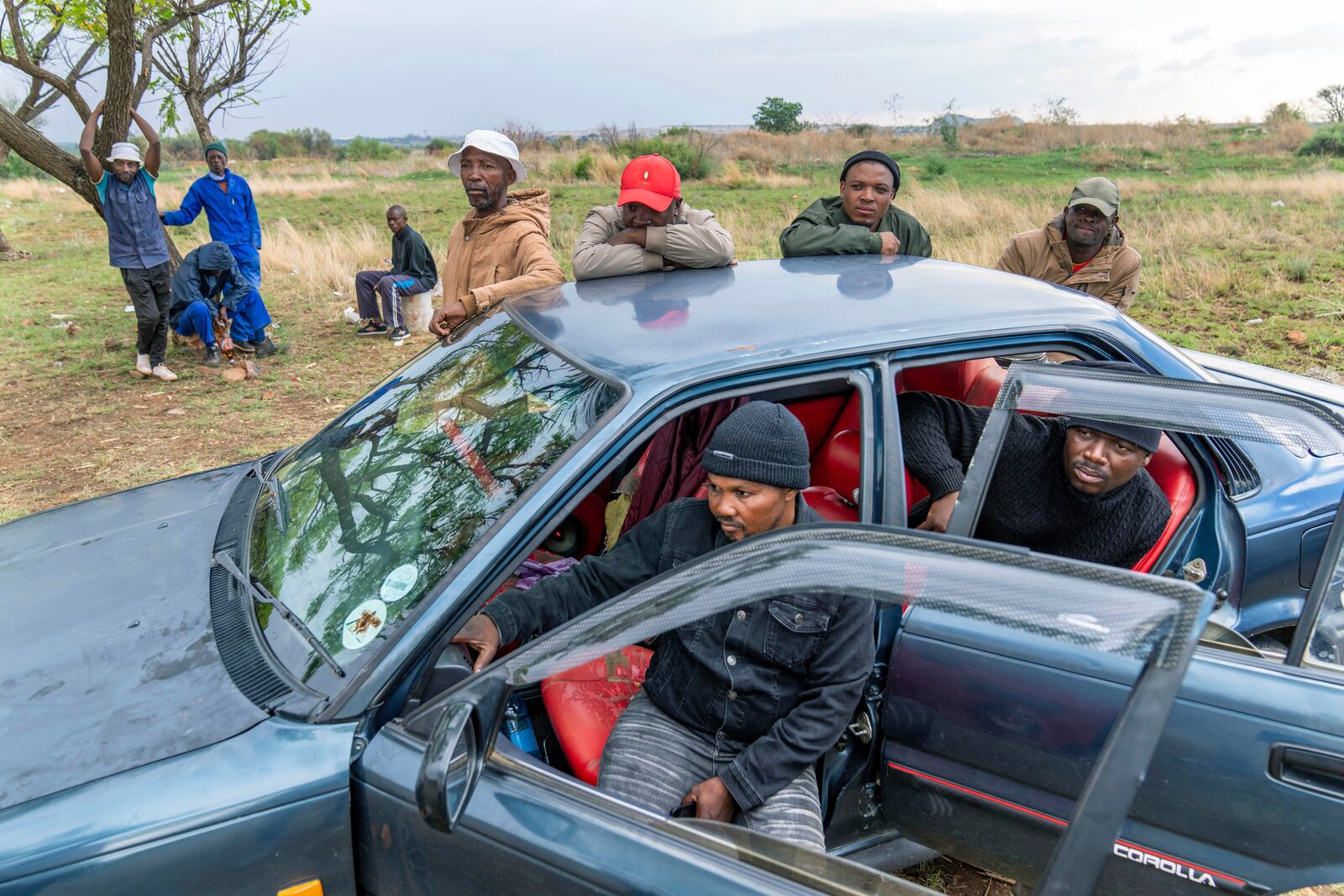 Relatives of miners and community members wait at a mine shaft where illegal miners are trapped in a disused mine in Stilfontein, South Africa, Thursday, Nov.14, 2024. (AP Photo/Jerome Delay)