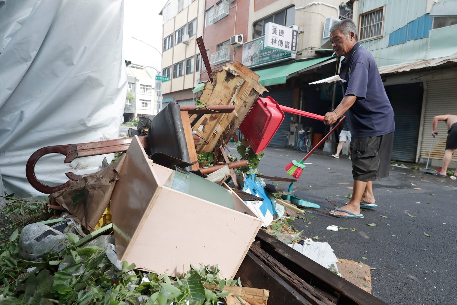 A man clears debris in the aftermath of Typhoon Krathon in Kaohsiung, southern Taiwan, Friday, Oct. 4, 2024. (AP Photo/Chiang Ying-ying)