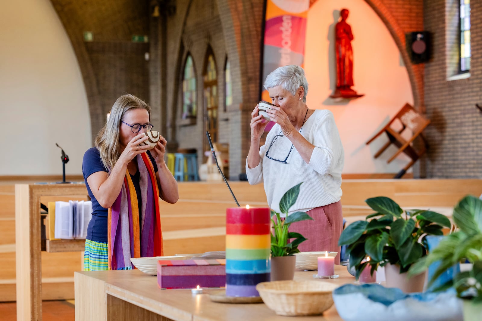 Laywomen Nancy Speeckaert, left, and Marijke Devaddere drink wine after the Eucharistic Prayer during a service they led at the Don Bosco church in Buizingen, Belgium, Sunday, Sept. 8, 2024. (AP Photo/Geert Vanden Wijngaert)