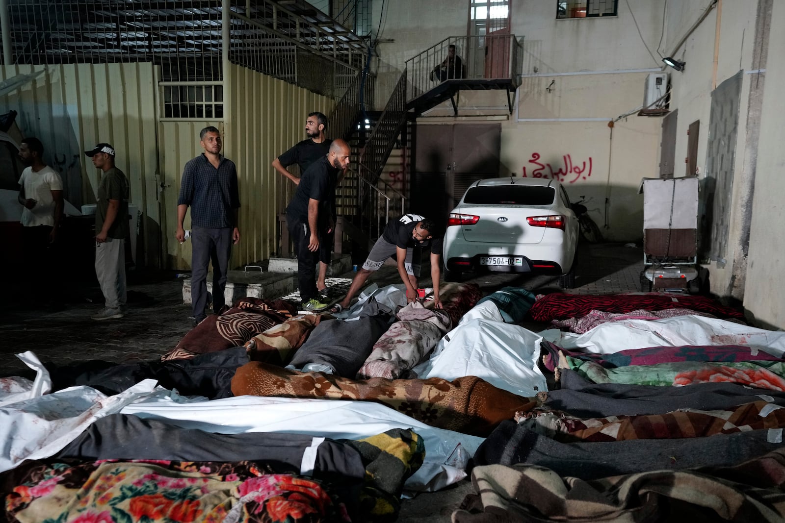 FILE - Palestinians check the bodies of their relatives killed in an Israeli bombardment of UNRWA school at Nusseirat refugee camp, in front of the morgue of al-Aqsa Martyrs hospital in Deir al-Balah, central Gaza Strip, early Thursday, June 6, 2024. (AP Photo/Abdel Kareem Hana, File)