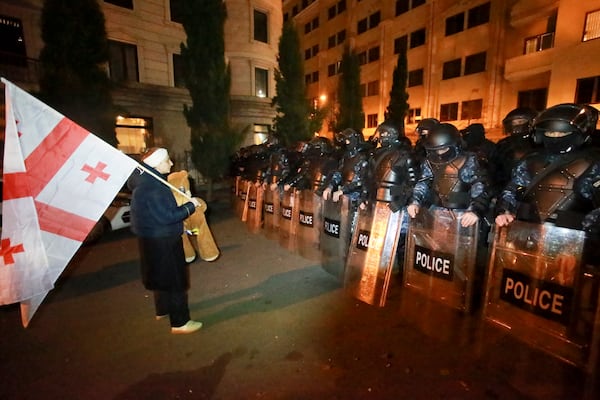 A demonstrator stands in front of police blocked protesters pouring into the streets following Georgian Prime Minister Irakli Kobakhidze's announcement, rallying outside the parliament building in Tbilisi, Georgia, on Friday, Nov. 29, 2024. (AP Photo/Zurab Tsertsvadze)