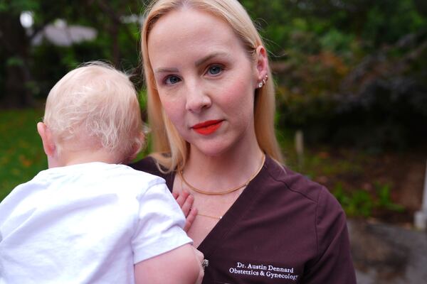Dr. Austin Dennard holds her son as she poses for a portrait at her home in Dallas, Friday, May 2, 2025. (AP Photo/LM Otero)