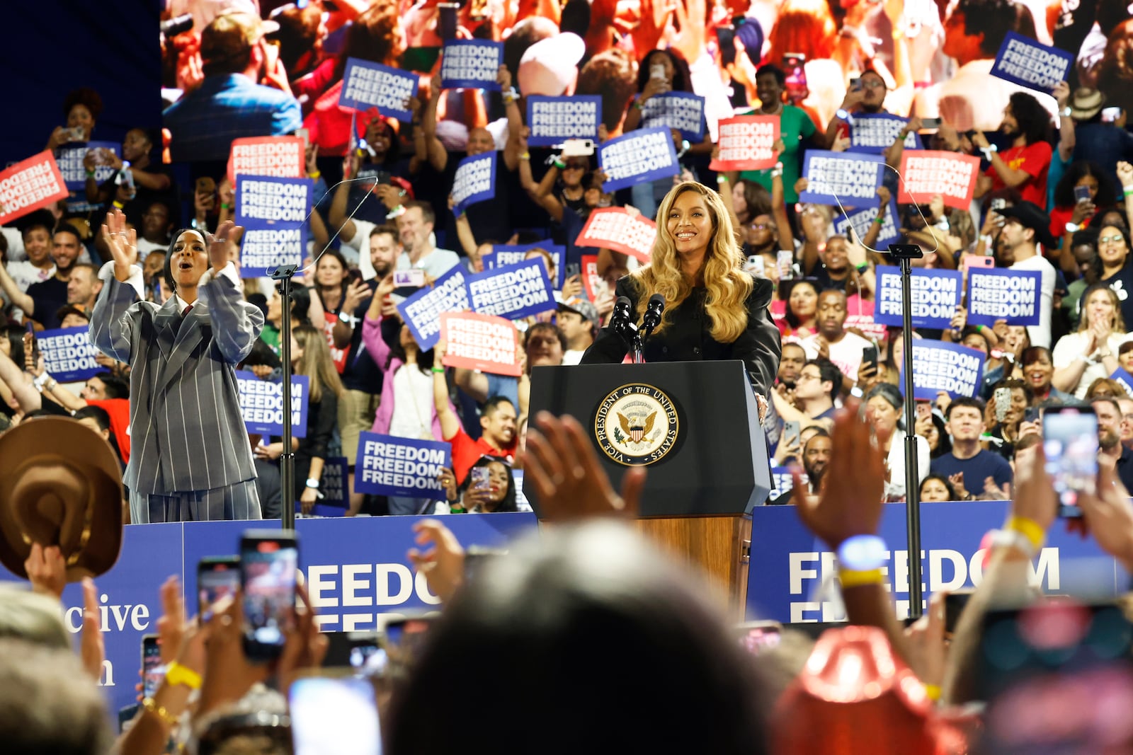 Musical artists Beyonce, right, and Kelly Rowland, left, on stage at a campaign event for Democratic presidential nominee Vice President Kamala Harris, Friday, Oct. 25, 2024, in Houston. (AP Photo/Annie Mulligan)