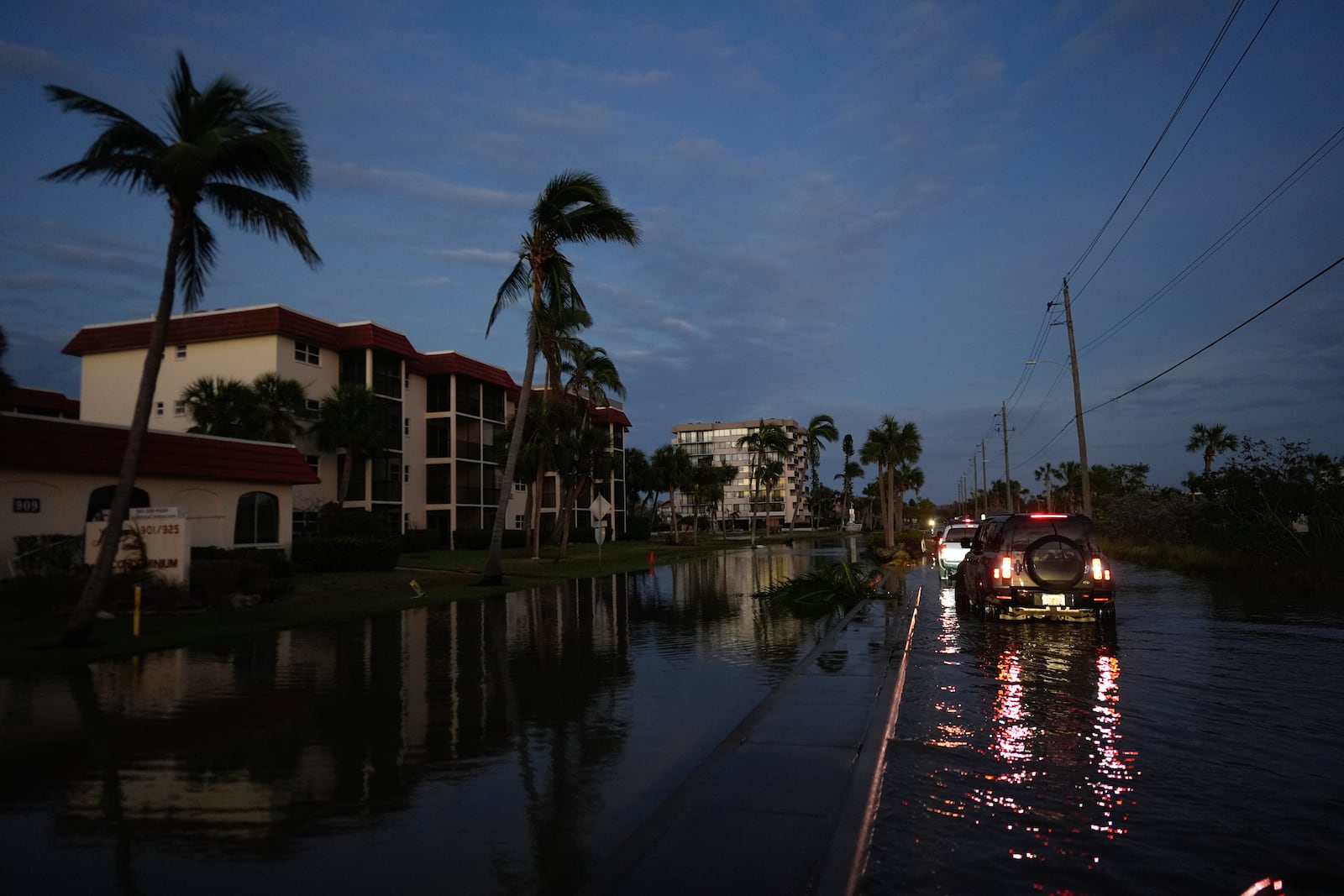 A car backs up after encountering deeper water on a flooded street in Siesta Key, Fla., following the passage of Hurricane Milton, Thursday, Oct. 10, 2024. (AP Photo/Rebecca Blackwell)