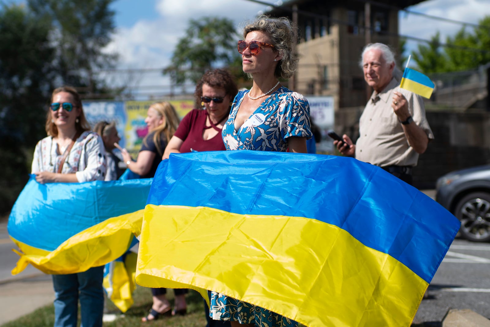 Kristina Ramanauskas, a first generation Lithuanian, waves a Ukrainian flag before President of Ukraine Volodymyr Zelenskyy's motorcade arrives at the Scranton Army Ammunition Plant in Scranton on Sunday, Sept. 22, 2024. (AP Photo/Laurence Kesterson)