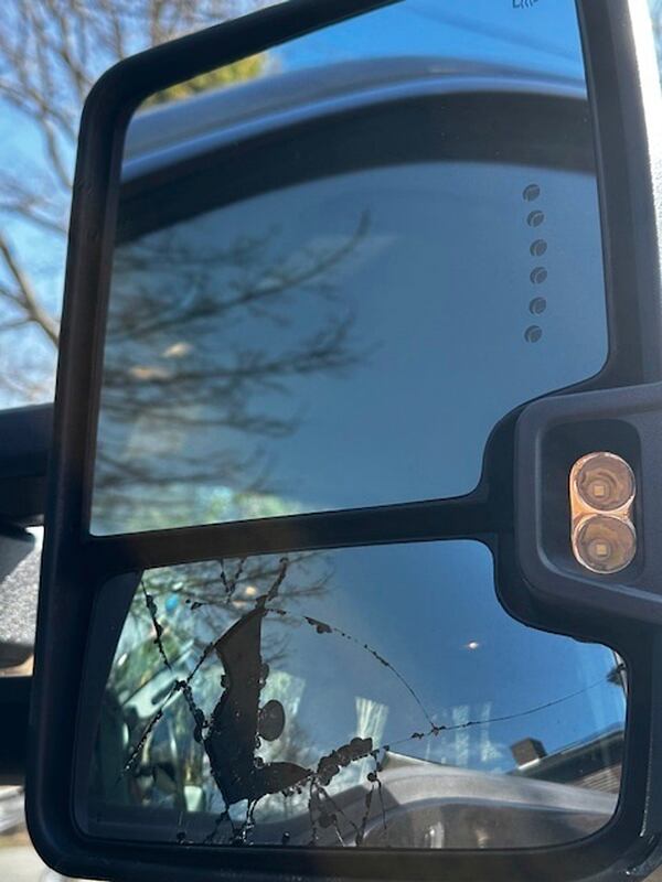 In this photograph provided by Janelle Favaloro, a recreational vehicle's broken side mirror, caused by a rogue woodpecker, is seen in the driveway of a home, during April 2025, in Rockport, Mass. (Janelle Favaloro photo via AP)