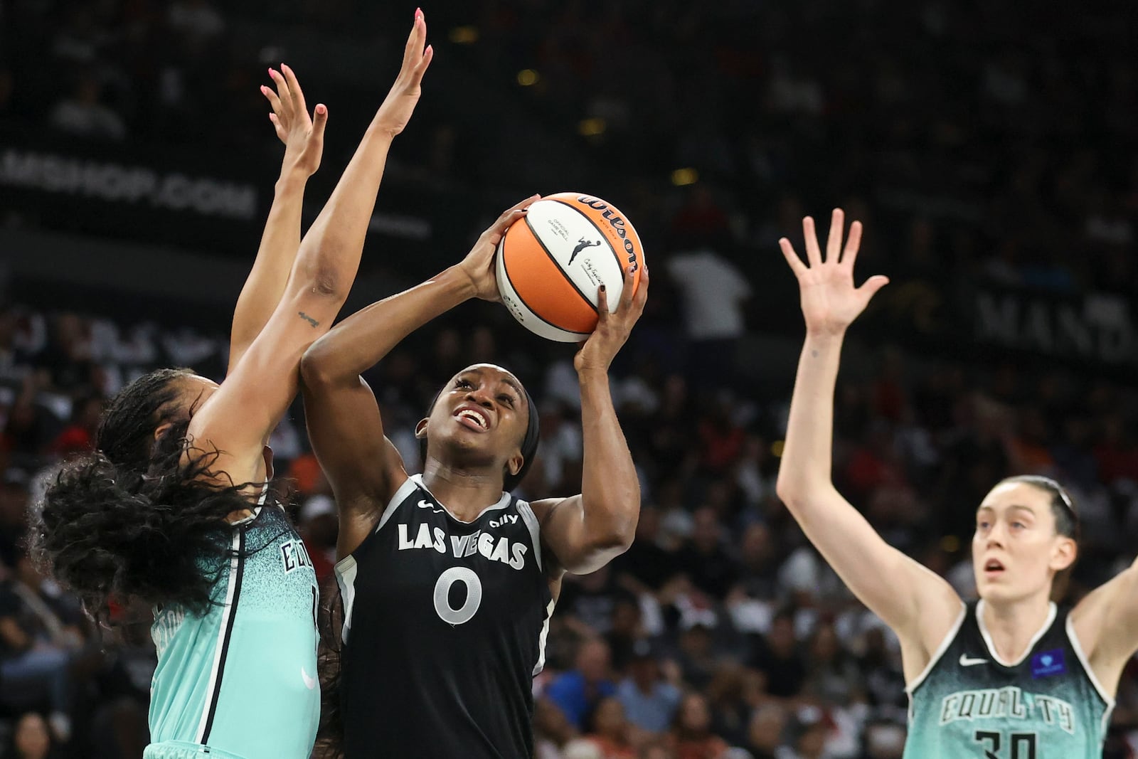 Las Vegas Aces guard Jackie Young (0) shoots over New York Liberty forward Betnijah Laney-Hamilton (44) during the first half of a WNBA Semifinal game Sunday, Oct. 6, 2024, in Las Vegas. (AP Photo/Ian Maule)