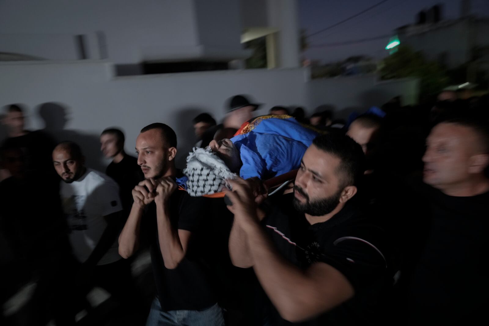 Mourners carry the body of Sameer A'mar, 55, during his funeral in the West Bank town of Shuweika, north of Tulkarem, Tuesday, Sept. 17, 2024. A'mar was shot dead by Israel forces near the separation barrier in mid-September according to Wafa, the official Palestinian news agency. (AP Photo/Majdi Mohammed)