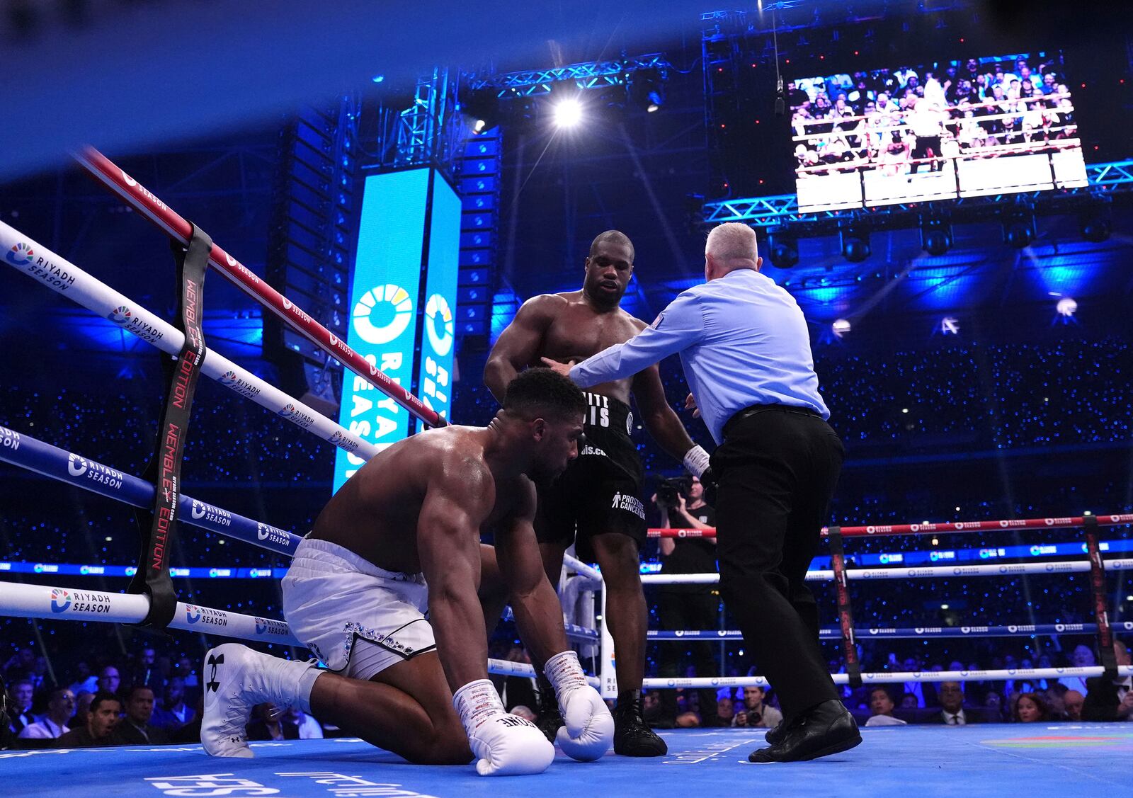 Daniel Dubois, centre, knocks down Anthony Joshua in the IBF World Heavyweight bout at Wembley Stadium, in London, Saturday, Sept. 21, 2024. (Bradley Collyer/PA via AP)