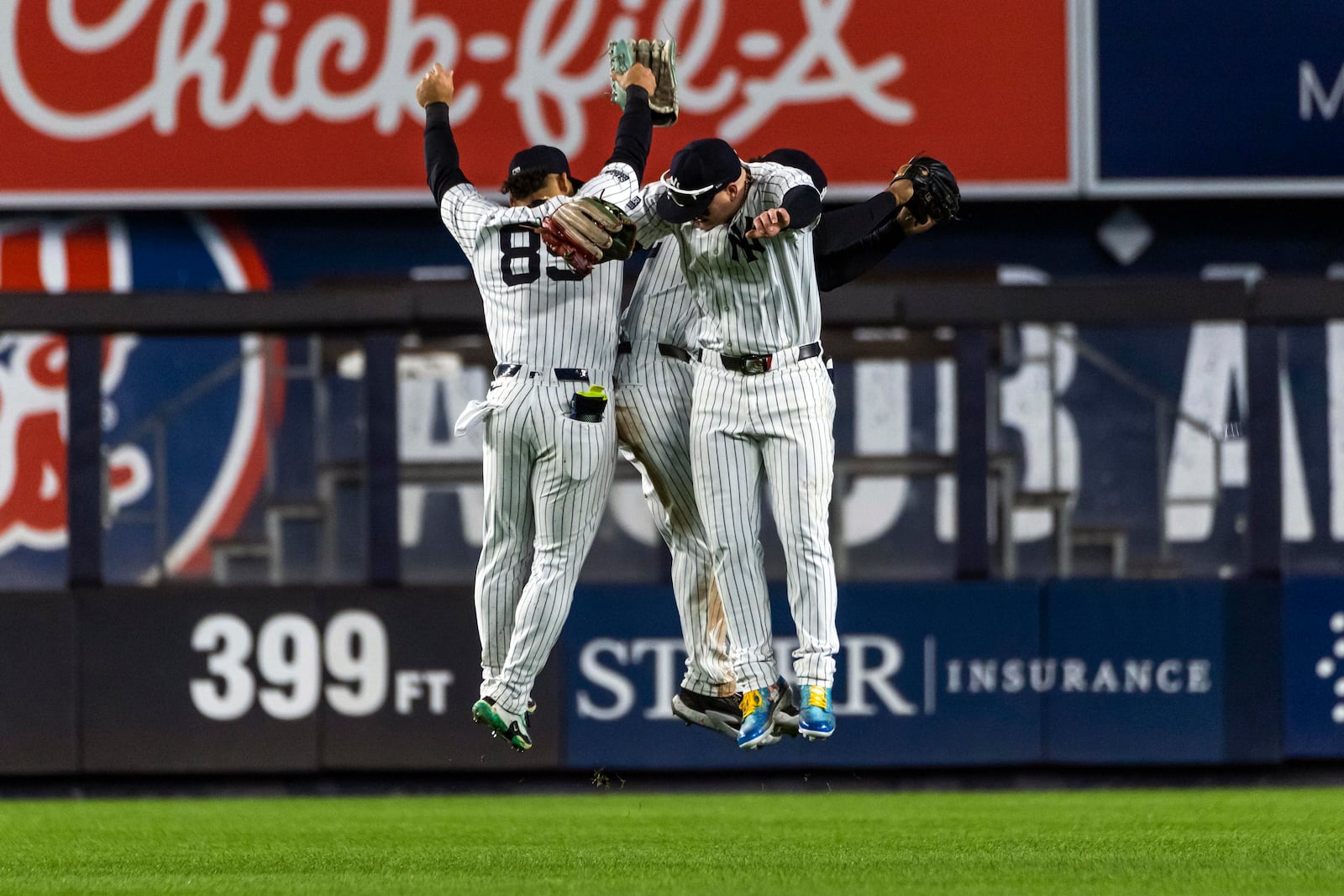 New York Yankees players Alex Verdugo, Jasson Dominguez and Trent Grisham celebrate at the end of the ninth inning of a baseball game against the Pittsburgh Pirates, Sunday, Sept. 29, 2024, in New York. (AP Photo/Eduardo Munoz Alvarez)