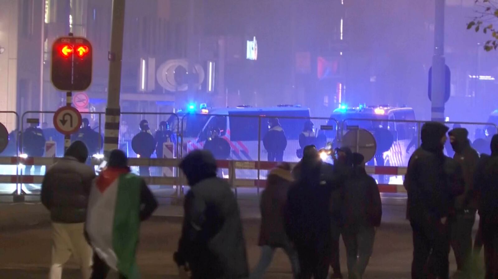 In this image taken from video, a group of pro-Palestinian protesters walk toward police line, with police vans driving in the background, near the soccer stadium in Amsterdam, Netherlands, Thursday, Nov. 7, 2024. (RTL Nieuws via AP)